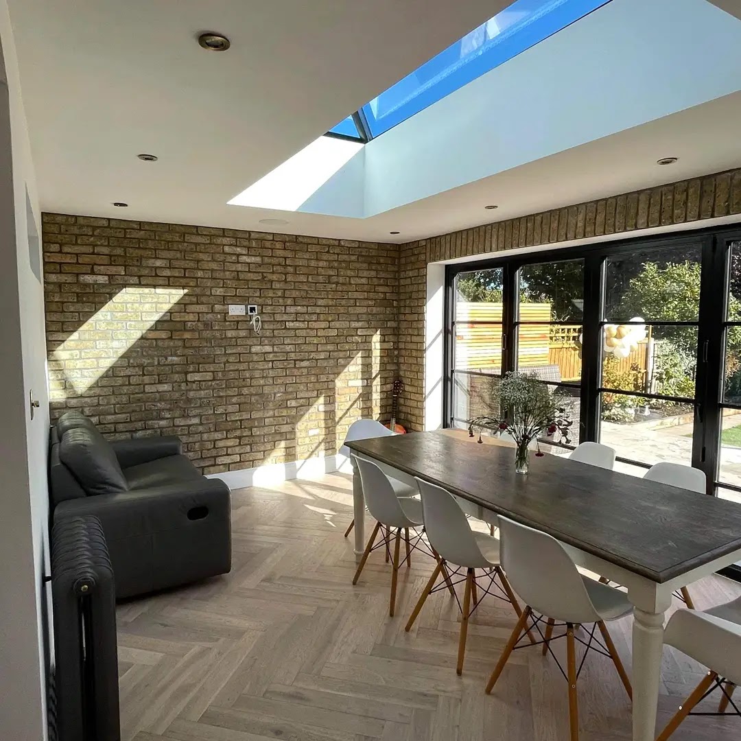 Grey-washed herringbone floor in a bright kitchen extension with a roof lantern